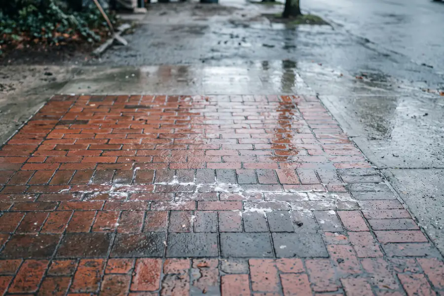 White efflorescence haze being removed from a brick and paver surface